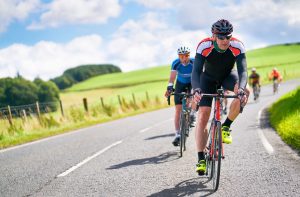 Men cycling down a curved road