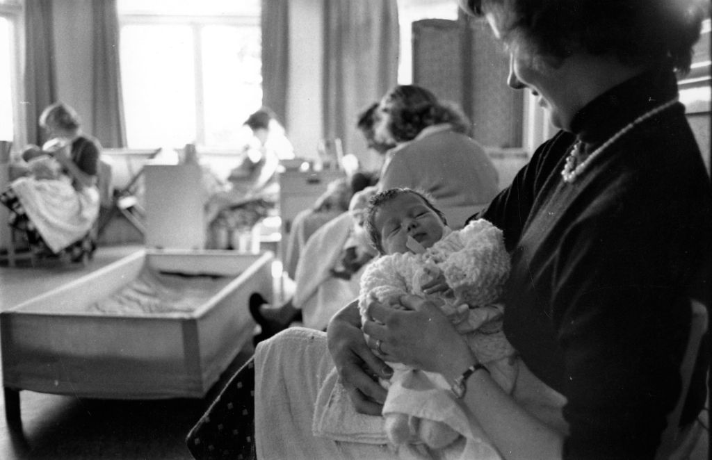 25th September 1954: An unmarried mother rocks her baby to sleep in a home run by the London Diocesan Council for Moral Welfare Work. 1954 (Photo by Joseph McKeown/Picture Post/Hulton Archive/Getty Images)