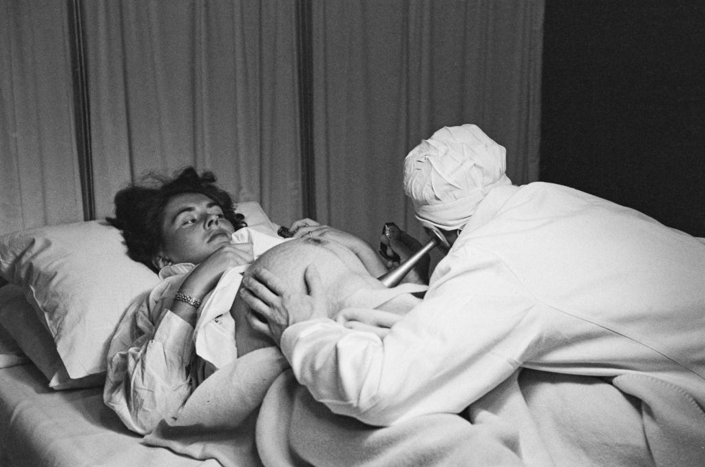 Doctor listens to baby's heartbeat via pinard horn, 1950.